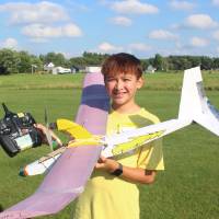 yellow team student poses with his plane